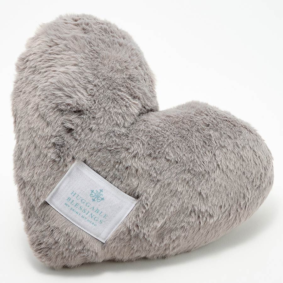A plush, gray weighted pillow in the shape of a heart with a label that reads 'Huggable Blessings'.