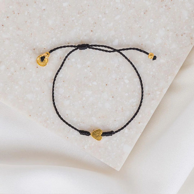 Petite black corded bracelet with small gold tone heart with slipknot closure