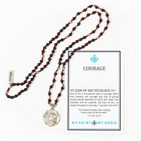 St. Joan of Arc necklace with red beads and silver medal on a white background, accompanied by a card with text.