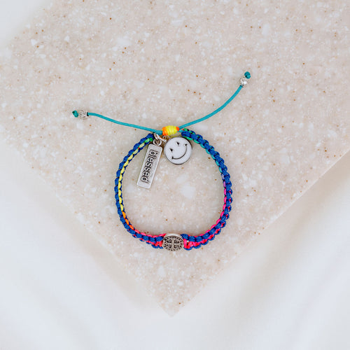 Kids Benedictine rainbow thread handwoven blessing bracelet with silver tone blessed charm and white enamel happy face