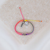 Kids Benedictine rainbow thread handwoven blessing bracelet with silver tone blessed charm and white enamel happy face