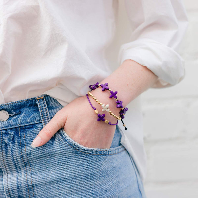 woman wearing my saint my hero lenten themed blessing bracelets in gold and silver with howlite crosses