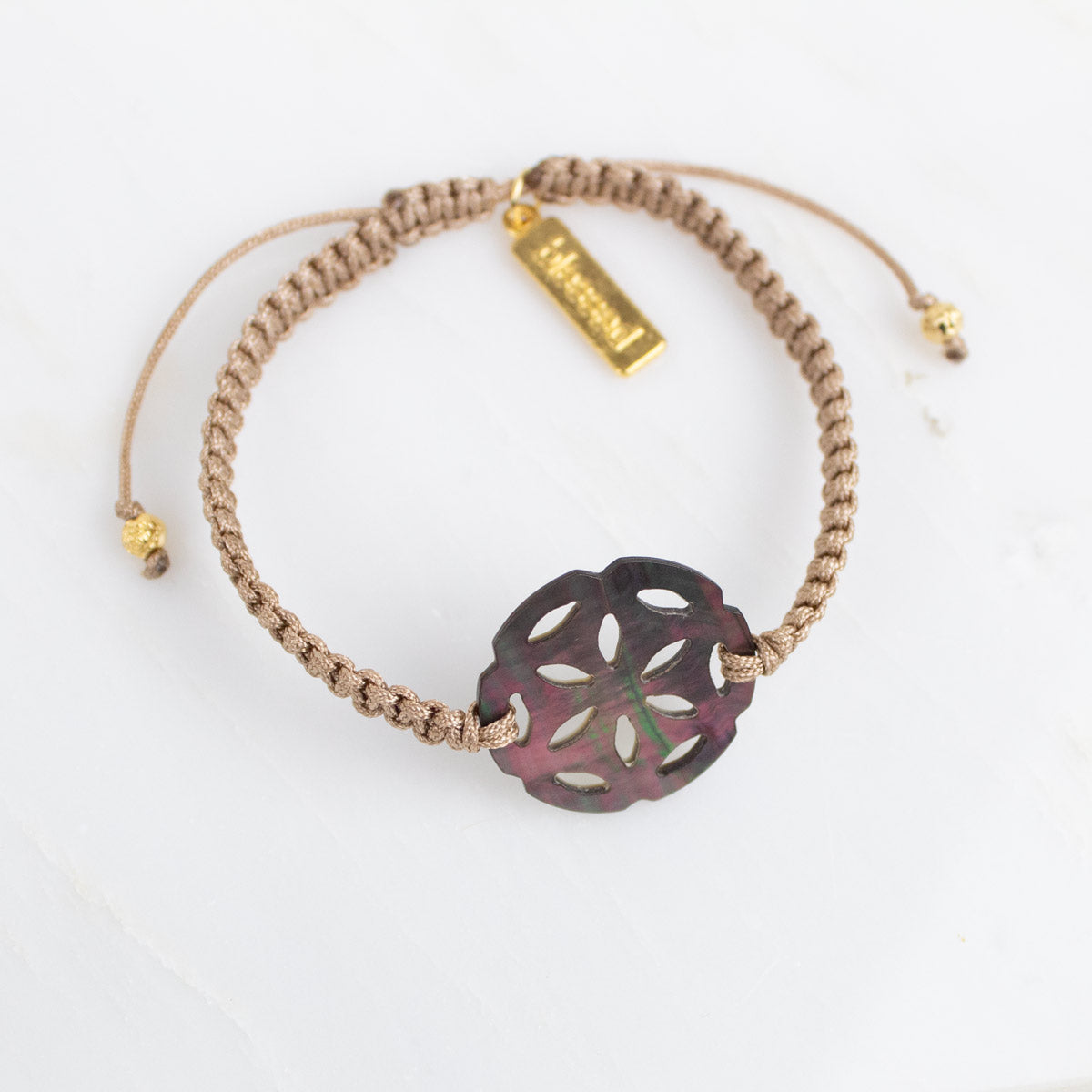 Bracelet with a decorative flower-shaped charm on a white background