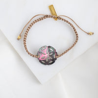 Bracelet with a mother of pearl rosette on a white background