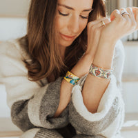 Woman wearing the My Saint My Hero Mary Star of the Sea gold-tone cuff bracelet with a colorful sacred Marian icon.