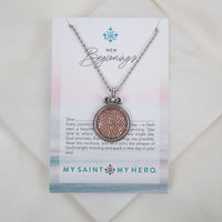 Necklace with pink textured pendant on a 'My Saint My Hero' card with text and logo.