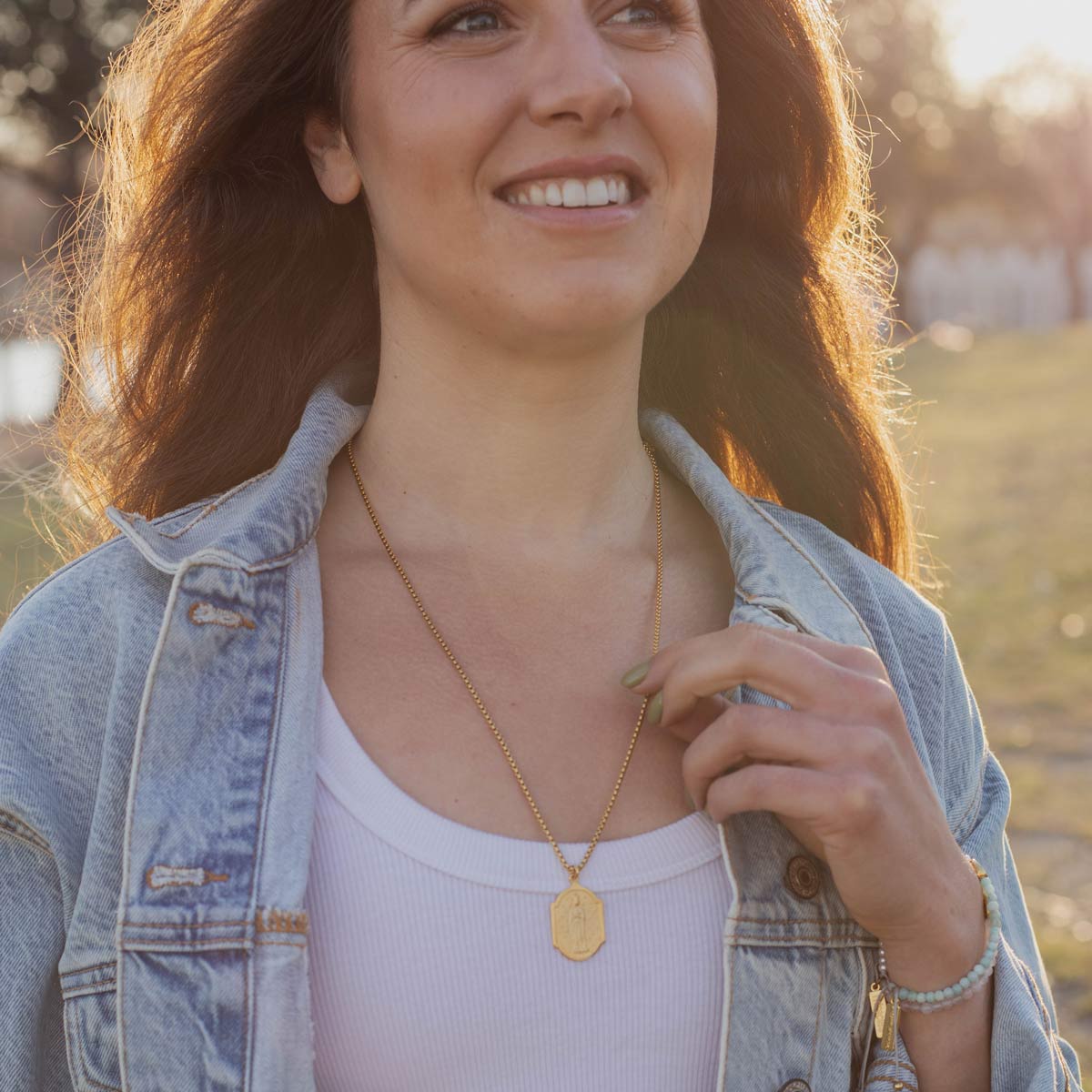 Woman wearing the Our Lady of Abundance gold plated necklace
