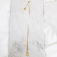 Our Lady of Fatima Gold Tone Necklace shown overhead on gold tone chain.