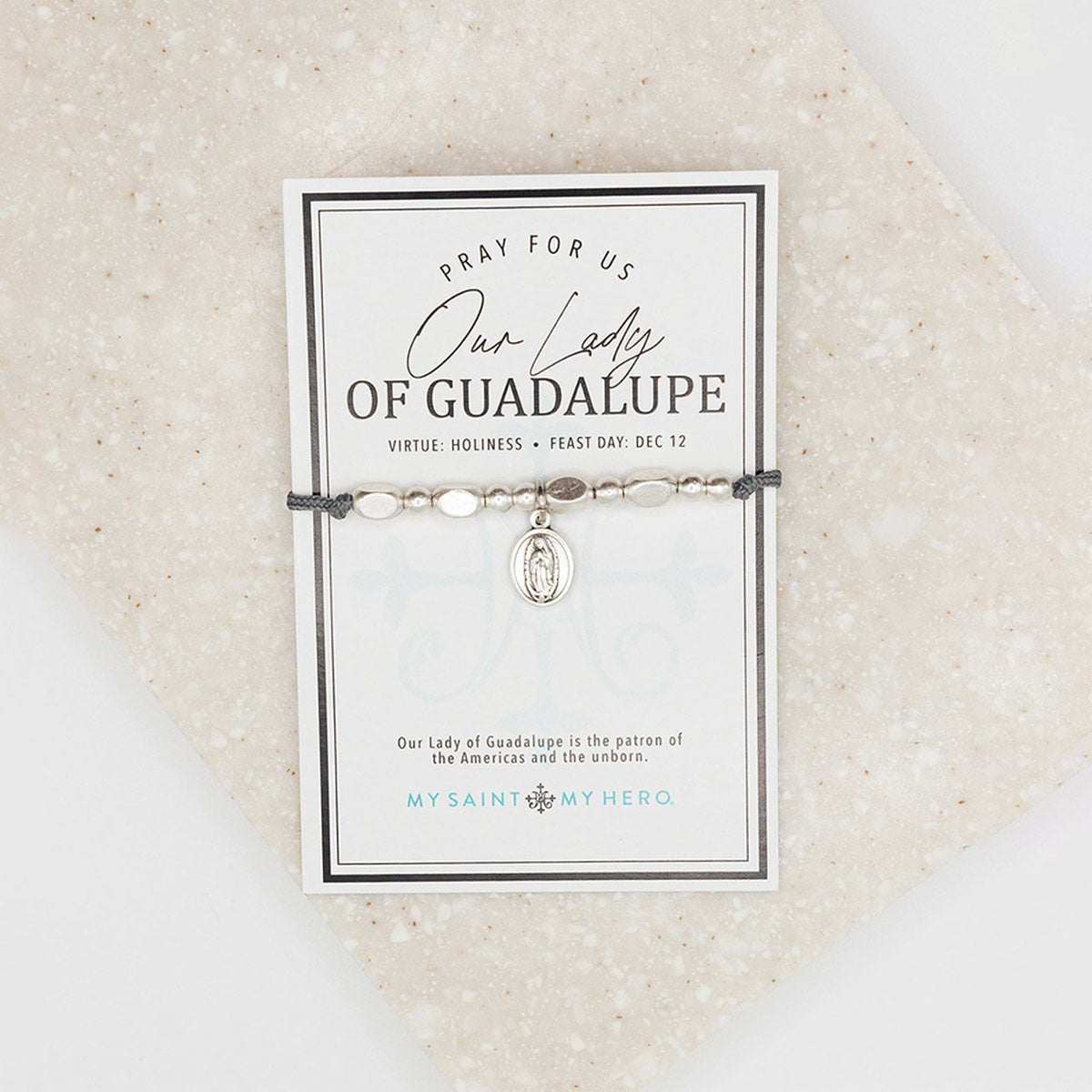Adjustable slate grey bracelet with silver-tone metal beads and a double-sided Our Lady of Guadalupe/Divine Mercy medal, presented on an inspirational card.
