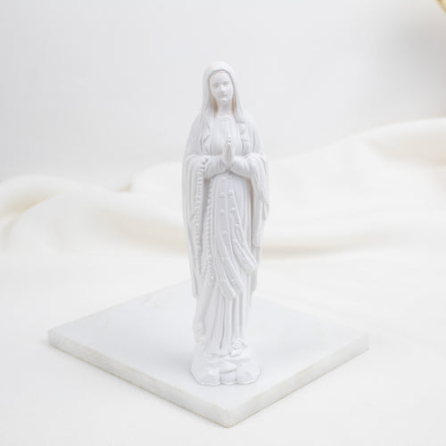 White Our Lady of Lourdes statue of a religious figure on a white platform