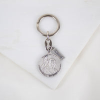 A silver-tone key ring featuring a double-sided medal with Pope Francis' coat of arms on both sides, displayed on a white background.