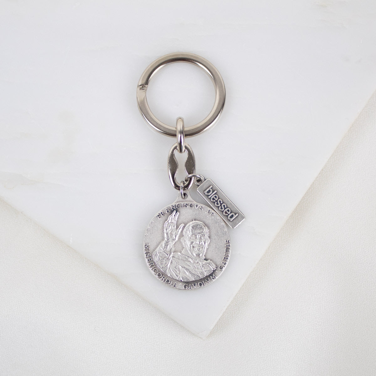 A silver-tone key ring featuring a double-sided medal with Pope Francis' coat of arms on both sides, displayed on a white background.
