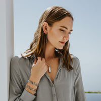 Women in gray shirt wearing a Silver Queen of the Universe Crystal Mary Pendant Necklace
