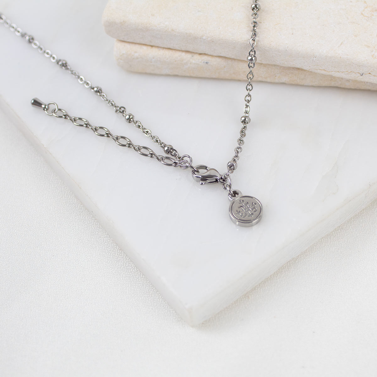 the lobster clasp, extender, and logo bug tag at teh back of the Queen of the Universe necklace