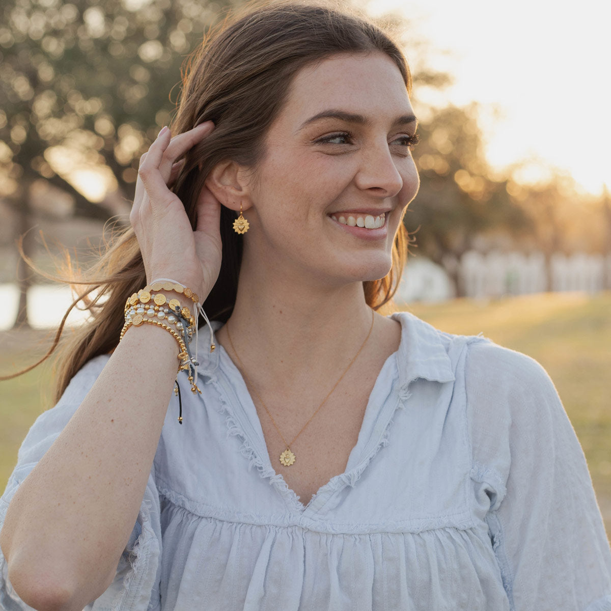 Young woman wearing Let Love Sacred Heart Earrings and matching necklace