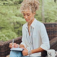 Sage Steele wearing the Sage Steele x My Saint My Hero Divine Grace amazonite bracelets while journaling