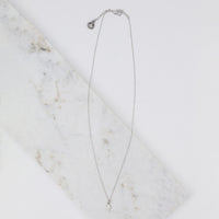 Over head flat lay photo of the silver Simply Faith Cross Necklace