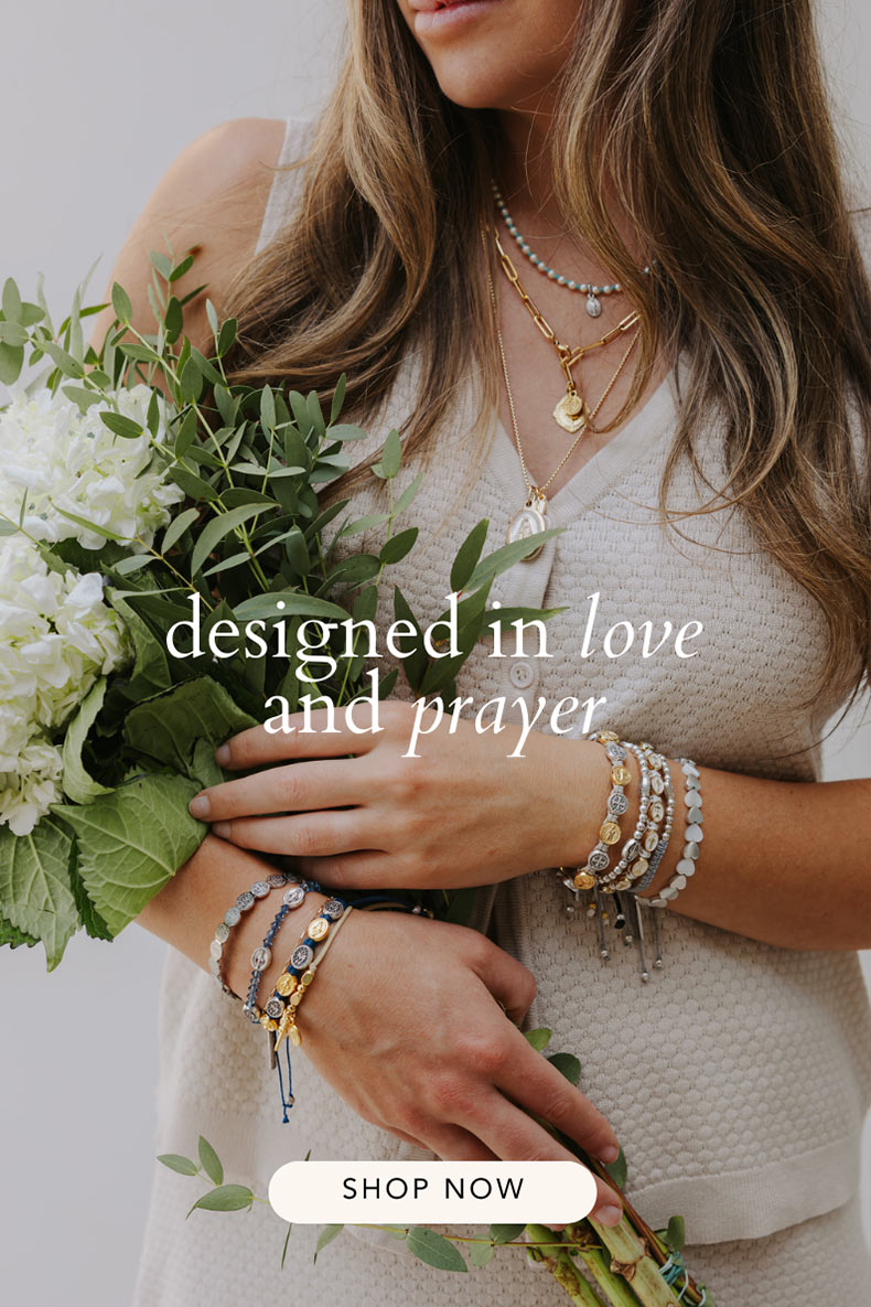 Woman holding a bouquet of flowers with jewelry, text 'designed in love and prayer', and 'Shop Now' button.