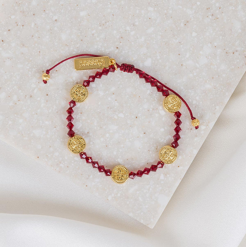 Ruby Red Crystal and Gold St. Amos Medals on a slip knot cording with a gold tag that says blessed