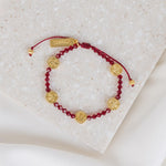 Ruby Red Crystal and Gold St. Amos Medals on a slip knot cording with a gold tag that says blessed