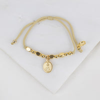 Gold bracelet with a pendant on a white background