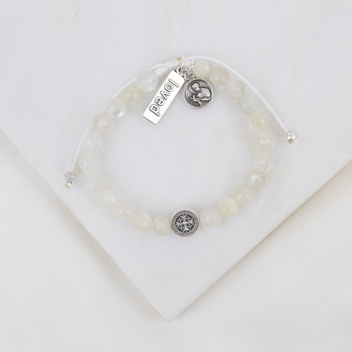 Moonstone gemstone Bracelet with  St. Gerard adn loved silver charms on a white background