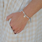 Hand wearing a St. Padre Pio Little Saints silver beaded bracelet 