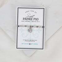 An image of the Saint Padre Pio Little Saints Bracelet with silver-tone metal beads and a Saint Padre Pio medal, presented on a card with information about the saint and the bracelet's purpose.