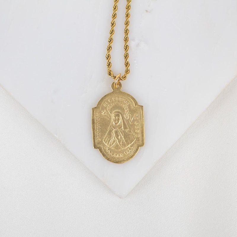 Gold necklace with a pendant on a white background