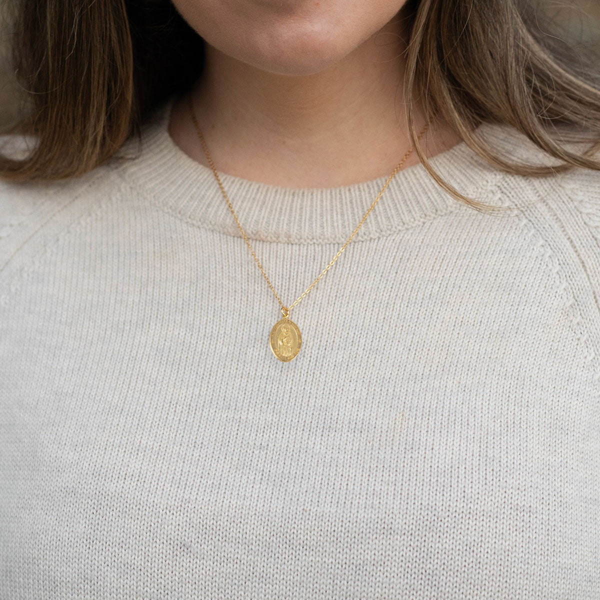 Woman wearing a St. Valentine Pendant Necklace in a tan sweater