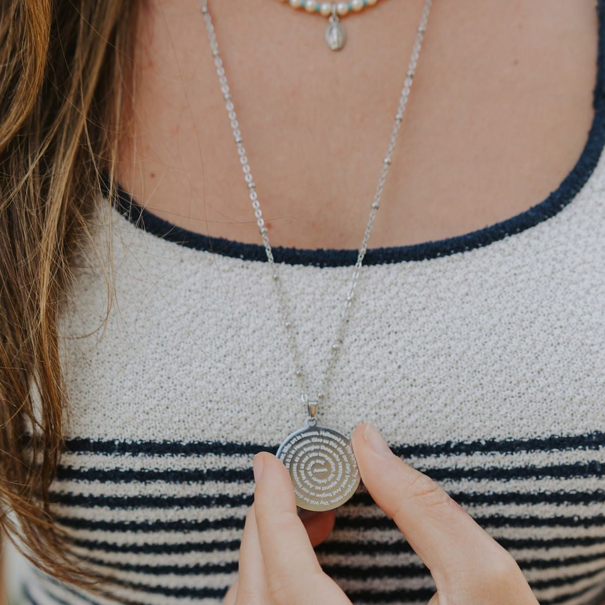 lose up details of the silver stainless steel Lord's Prayer circular engraved pendant