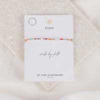 Walk by faith.  i am&nbsp;confident.  Kindness starts within. Plant the seed of kindness and watch it bloom all around you. Each piece is handmade by women in Kampala, Uganda.  Adjustable&nbsp;tan cording which ranges from 9.75" to 13.5"&nbsp;circumference Handwoven in Kampala, Uganda Responsibly sourced materials Seed Beads&nbsp; Medals made in Italy On an inspirational card