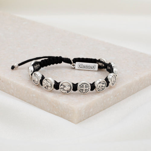 Saints and Heroes adjustable cording bracelet with silver medals and black cording on stone