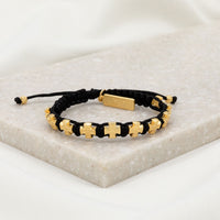 ten gold tone cross medals and a faith tag on handwoven black cording