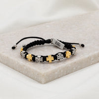 alternating gold and silver tone cross medals on black cording with a silver tone faith tag at slip knot