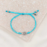 silver-tone St. Benedict medal on turquoise bracelet cording with a slipknot closure