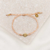 Gold-tone St. Benedict medal on copper metallic cording with a slipknot closure