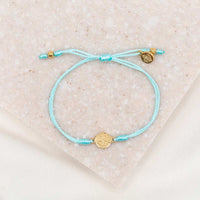 gold-tone St. Benedict medal on mint bracelet cording with a slipknot closure