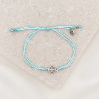 silver-tone St. Benedict medal on mint bracelet cording with a slipknot closure