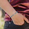 close up of wrist of girl wearing a December Crystal Birthday Blessing Bracelet in turquoise and silver tone