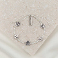  Bracelet with clear crystal beads and five silver tone Benedictine medals and a silver tone charm tag that says "blessed"