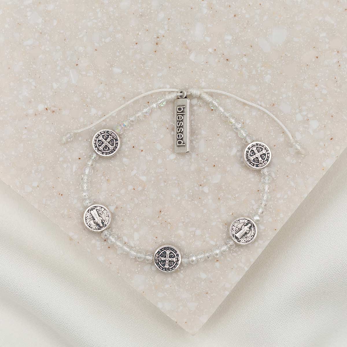  Bracelet with clear crystal beads and five silver tone Benedictine medals and a silver tone charm tag that says "blessed"