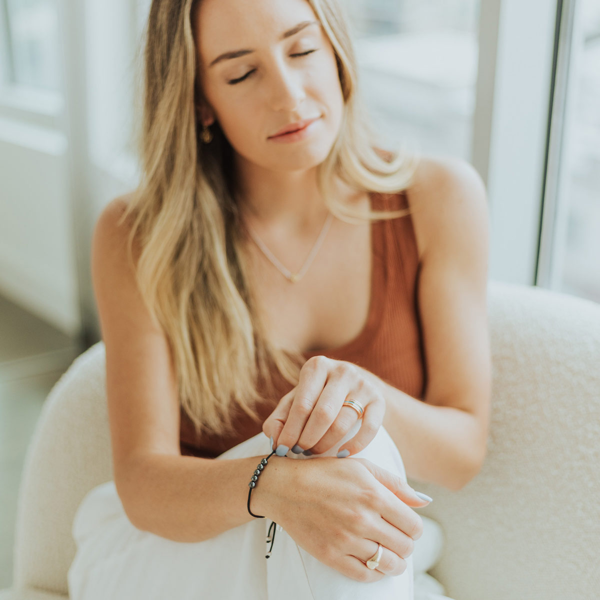 Young woman praying with the St Ignatius of Loyola Spiritual Awareness Bracelet