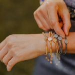 Close up of Share the Love Love Lights the Way Crystal Pearl Bracelets on Caitlin Stamos Wrist