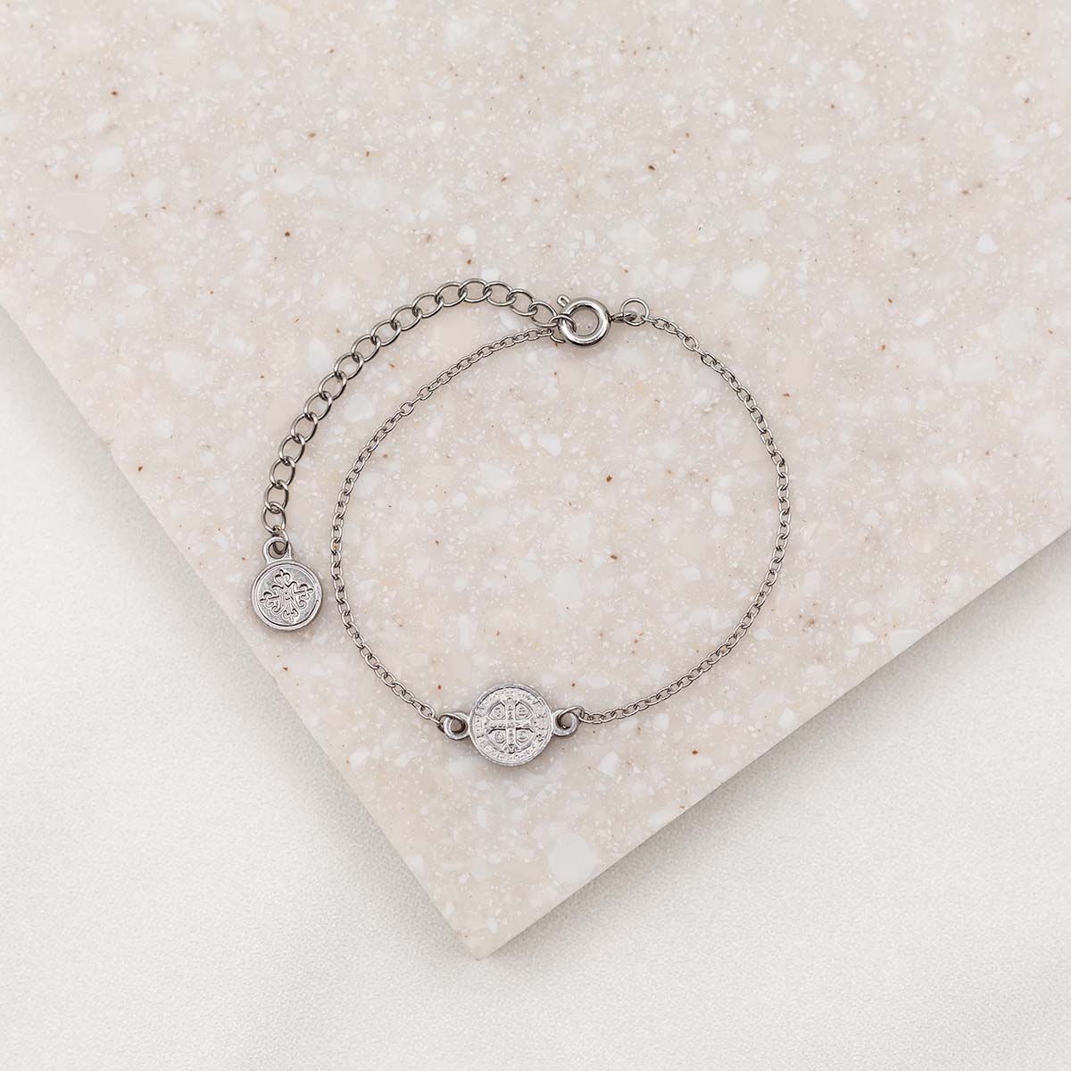 Small chain bracelet in silver tone with benedictine medal, two inch chain extender with a small round silver tone logo bug charm on the end