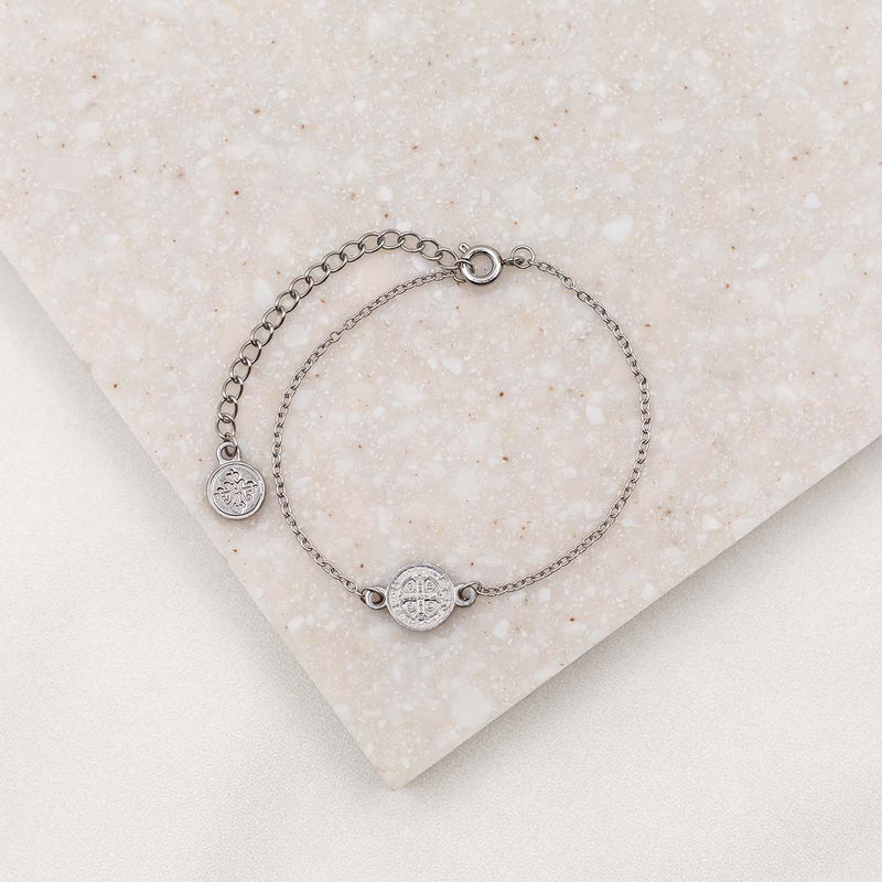 Small chain bracelet in silver tone with benedictine medal, two inch chain extender with a small round silver tone logo bug charm on the end