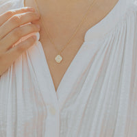 Gold Mary Medal on a petite gold dipped station chain worn by a women in a white blouse
