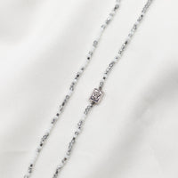 close up of the Auspice Maria Medal silver tone on silver and white beaded prayer rope