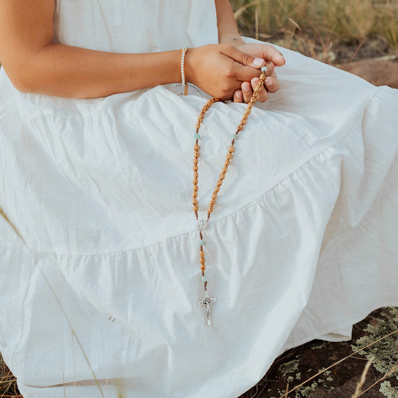 Olive Wood and Amazonite Medjugorje Rosary held by young person in field in white dress