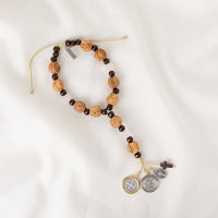 A door hanger made of hand-carved olive wood, featuring a two-tone Benedictine medal, a howlite cross, and silver-tone Miraculous Mary and Archangel Michael medals.